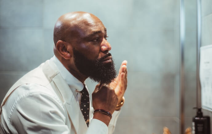 bearded man applying beard oil